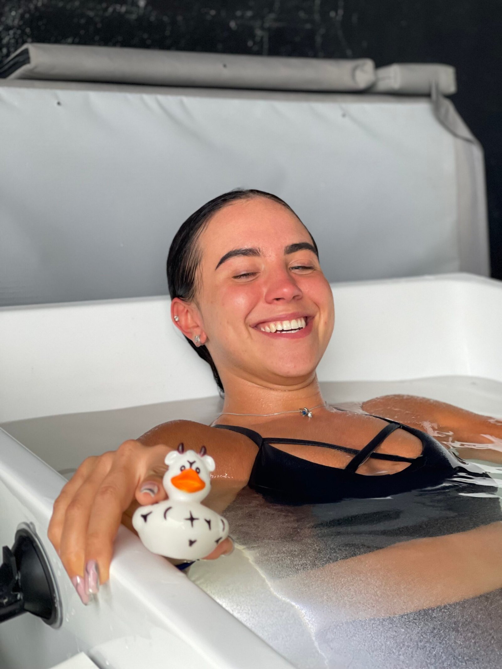 Guest smiling in a cold plunge tub at The Space Fort Lauderdale
